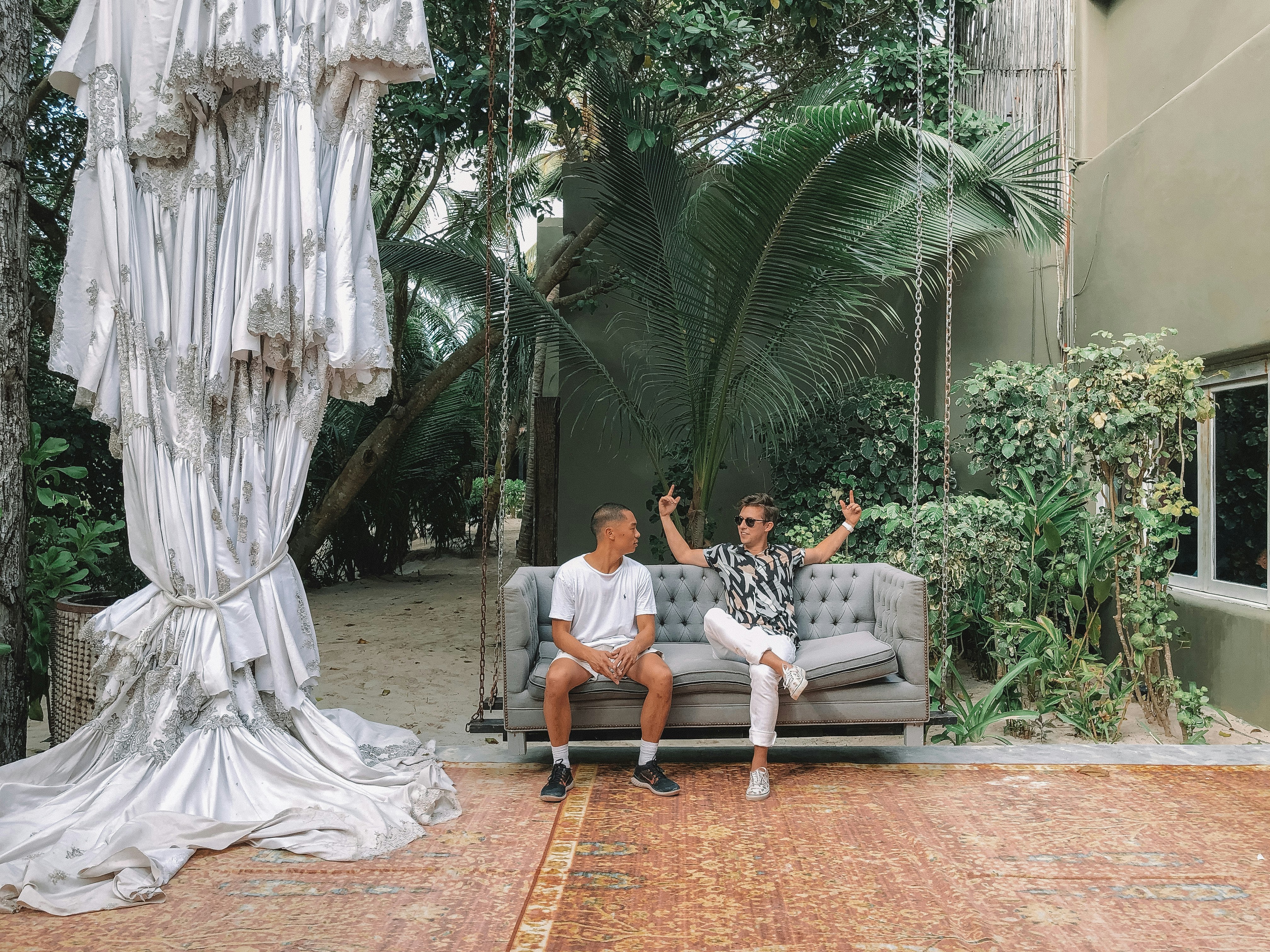 two men sitting on sofa while talking to each other